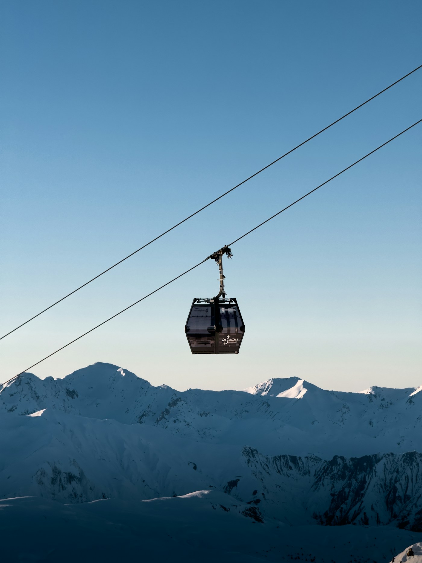 Télécabine montant au-dessus des montagnes enneigées